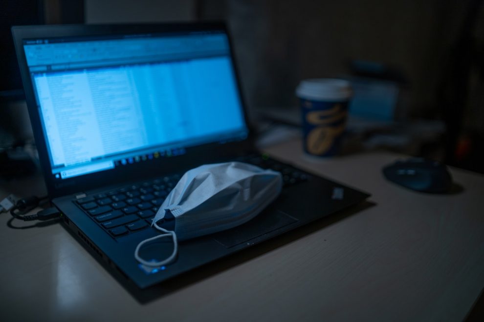 Computador portátil durante teletrabalho e máscara de COVID-19