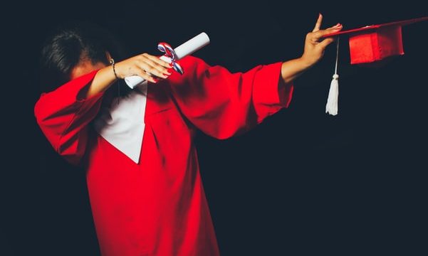 Mulher jovem licenciada com traje da cerimónia de graduação de curso de ensino superior numa universidade. Portugal tem 40% de jovens licenciados